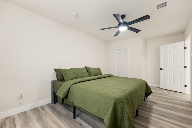 bedroom featuring light wood-style flooring, visible vents, and baseboards