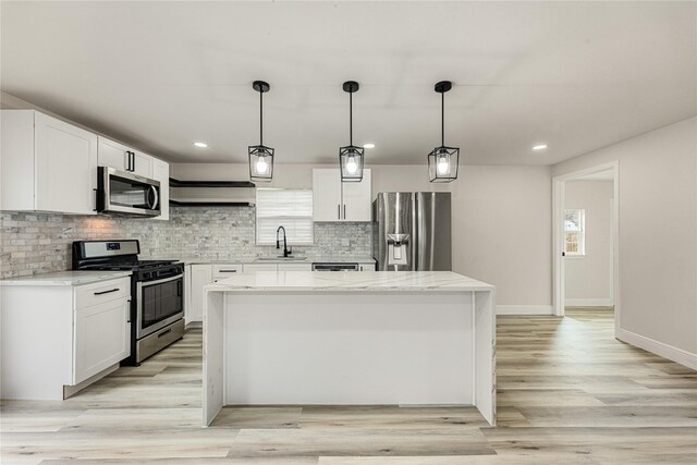 kitchen featuring appliances with stainless steel finishes, a center island, and white cabinetry