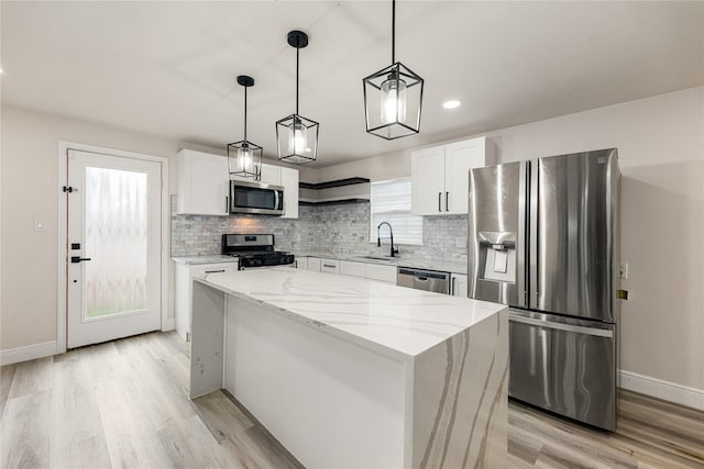 kitchen with open shelves, decorative backsplash, appliances with stainless steel finishes, white cabinets, and a sink