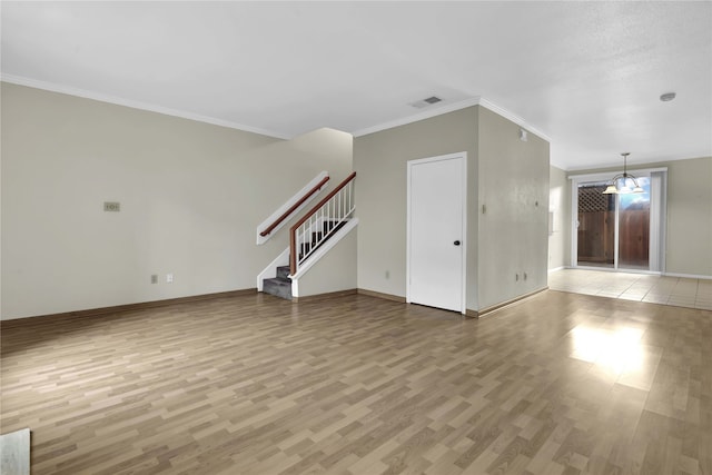 unfurnished living room featuring ornamental molding, hardwood / wood-style flooring, and a notable chandelier