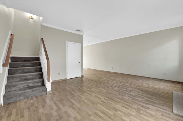 unfurnished living room with light wood-type flooring and crown molding