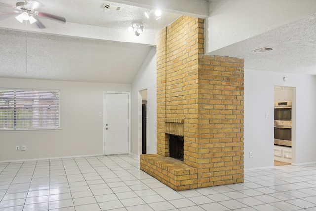 unfurnished living room featuring a brick fireplace, ceiling fan, light tile patterned floors, and a textured ceiling