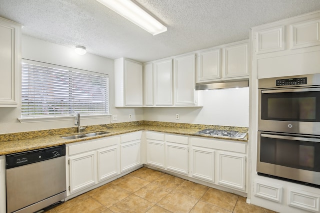 kitchen featuring light tile patterned floors, white cabinets, stainless steel appliances, and sink