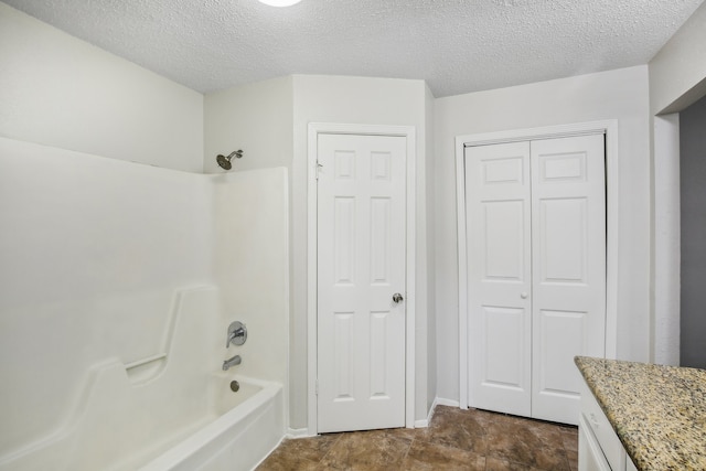 bathroom featuring vanity, bathing tub / shower combination, and a textured ceiling