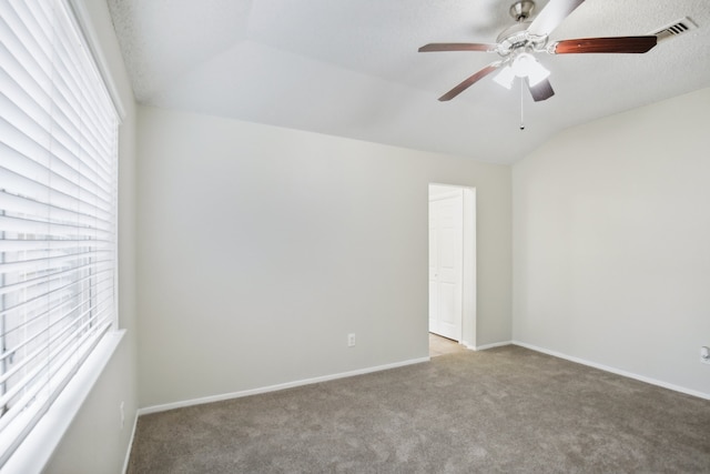 carpeted spare room with ceiling fan, a textured ceiling, and lofted ceiling