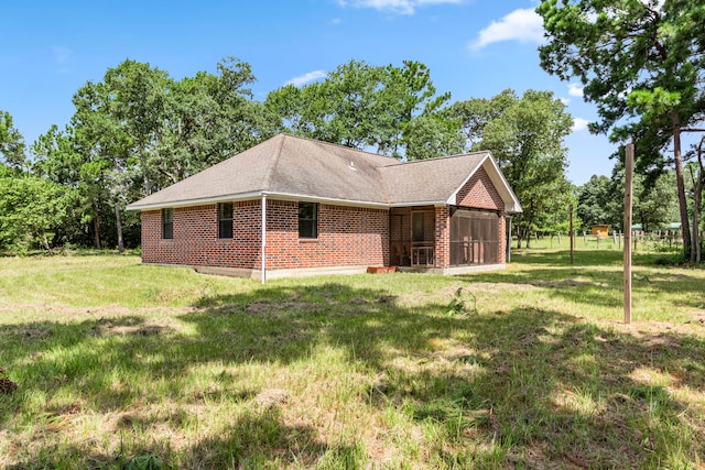 rear view of house with a sunroom and a yard