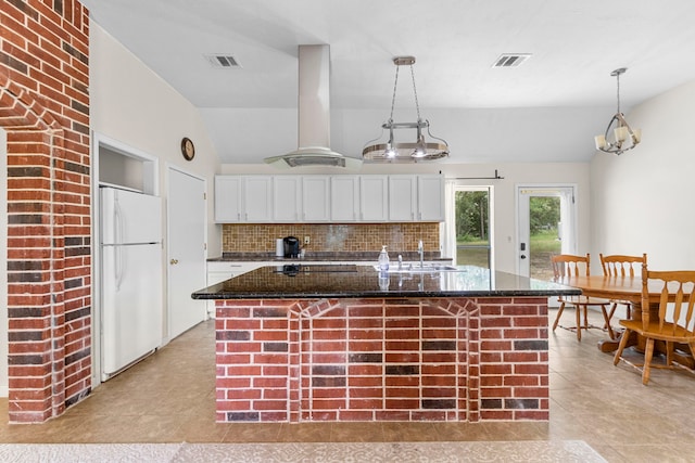 kitchen featuring pendant lighting, island exhaust hood, white fridge, and white cabinetry