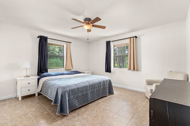 tiled bedroom with ceiling fan and multiple windows