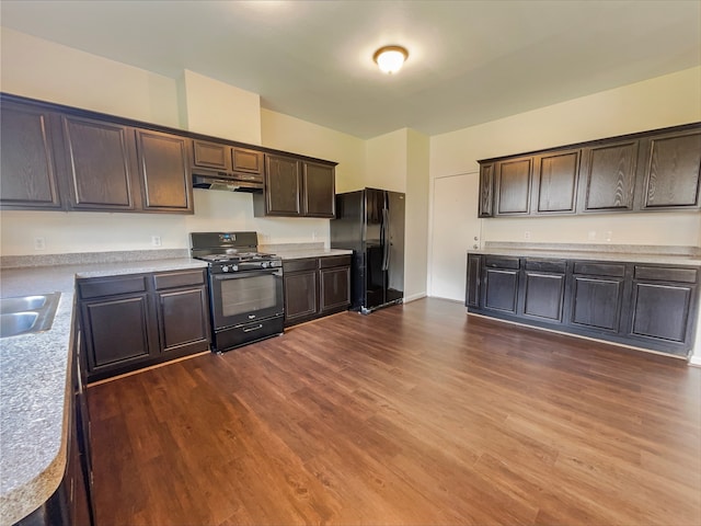 kitchen with black appliances, dark brown cabinets, and dark wood-type flooring