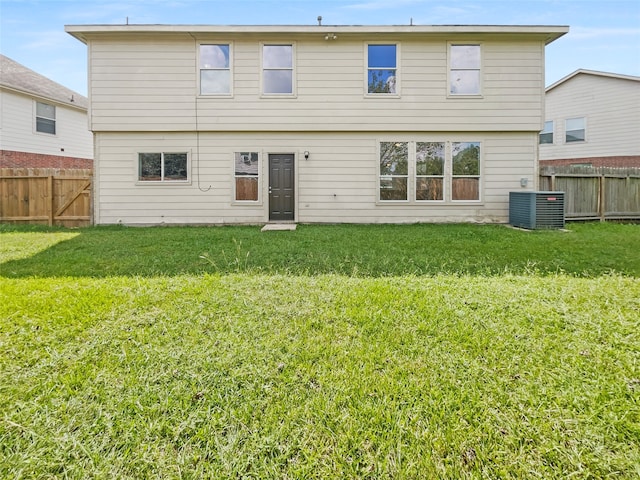 rear view of property featuring central AC and a yard