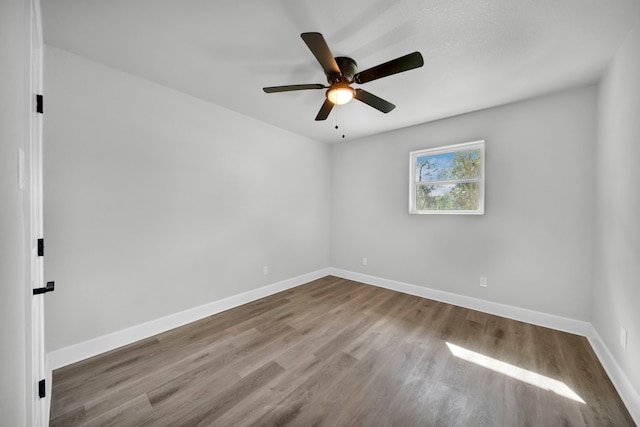 spare room with hardwood / wood-style floors and ceiling fan