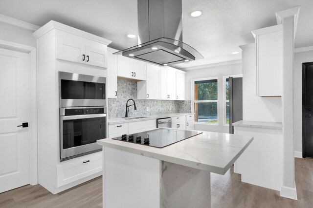 kitchen featuring light hardwood / wood-style floors, white cabinets, island range hood, a kitchen island, and appliances with stainless steel finishes