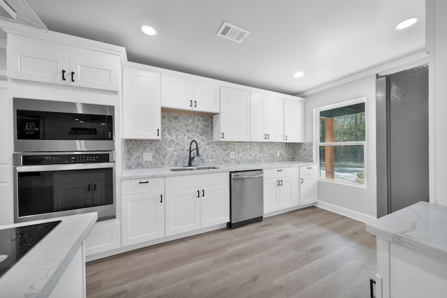 kitchen with appliances with stainless steel finishes, sink, and white cabinets