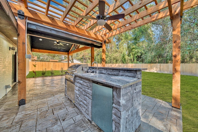 view of patio / terrace with a pergola, ceiling fan, an outdoor kitchen, and sink