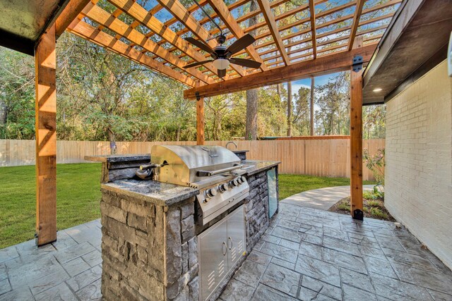 view of patio / terrace with exterior kitchen, a pergola, ceiling fan, and a grill