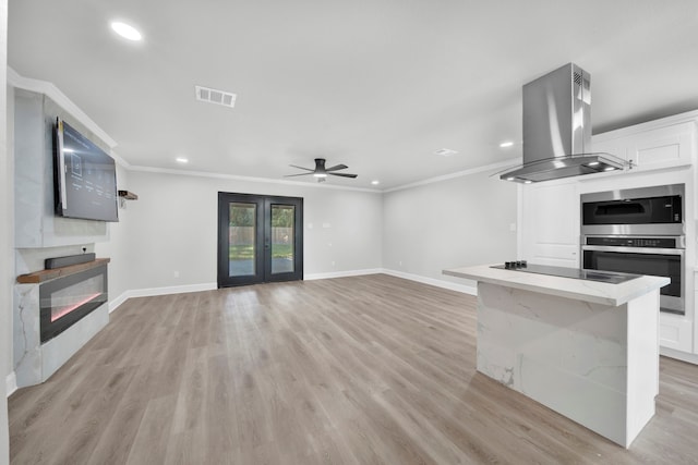 unfurnished living room with light hardwood / wood-style flooring, ceiling fan, and crown molding