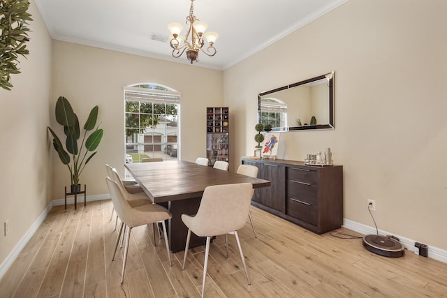 dining area with light hardwood / wood-style flooring, an inviting chandelier, and ornamental molding