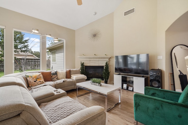 living room with high vaulted ceiling and light hardwood / wood-style floors