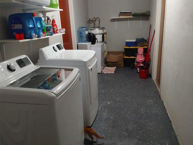 clothes washing area featuring electric water heater and washer and dryer