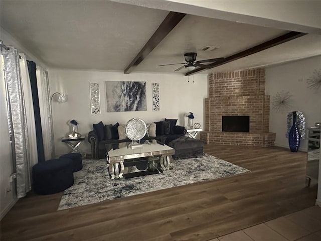 living room with ceiling fan, hardwood / wood-style flooring, a fireplace, and beam ceiling