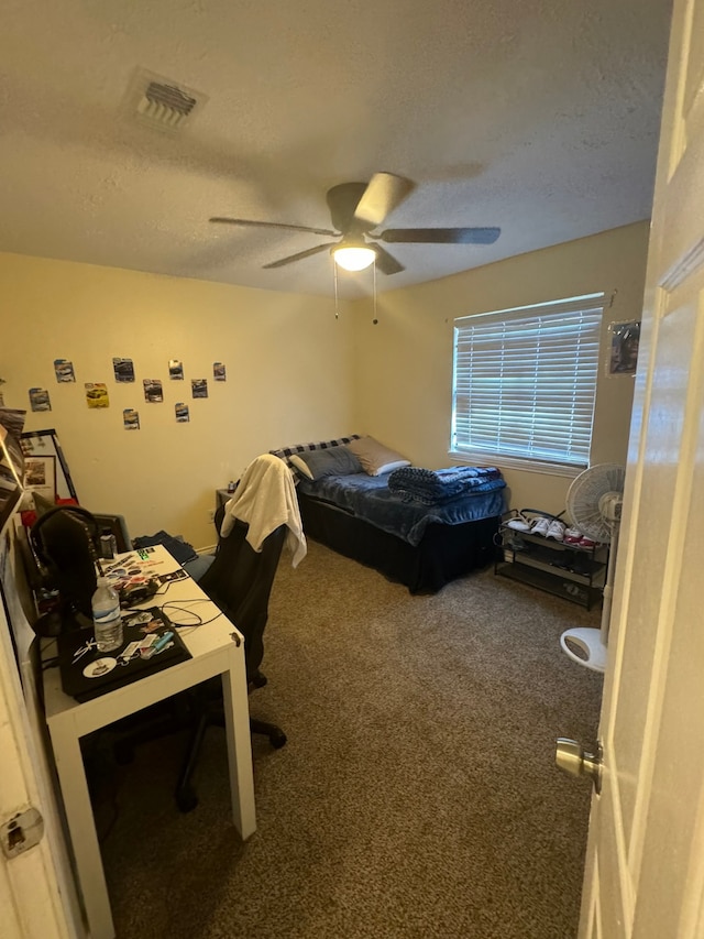 bedroom featuring ceiling fan, a textured ceiling, and carpet flooring