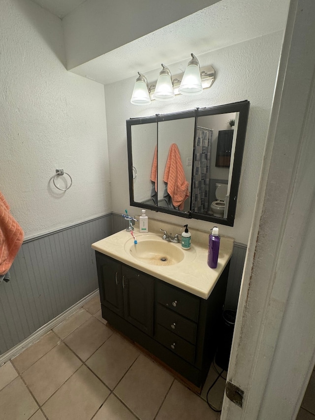 bathroom with tile patterned flooring, vanity, and toilet