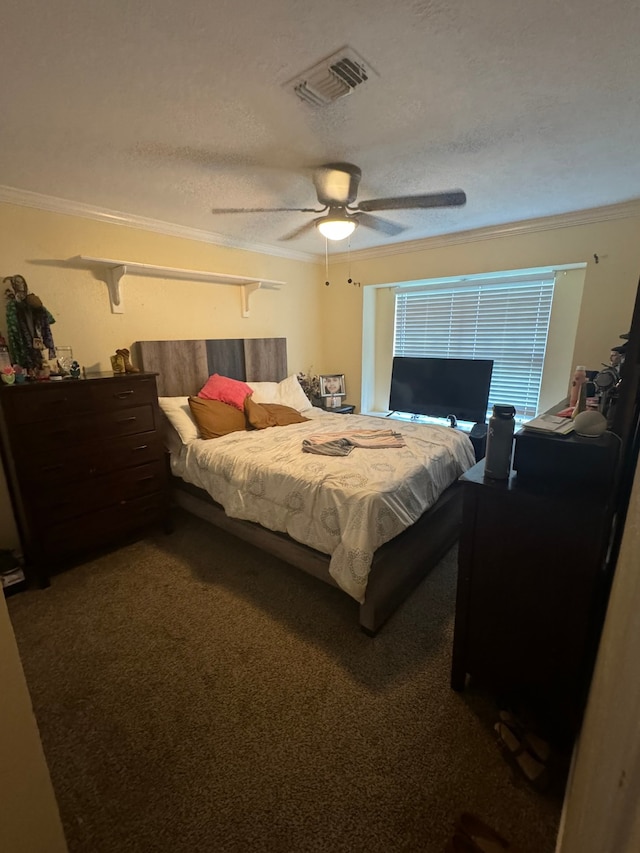 carpeted bedroom featuring ornamental molding, ceiling fan, and a textured ceiling