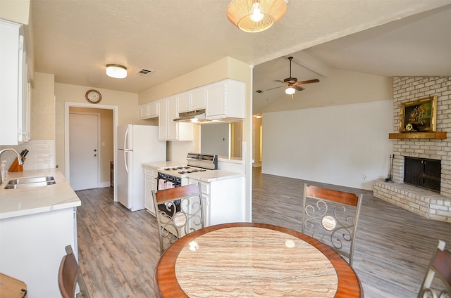 kitchen featuring white appliances, sink, white cabinetry, ceiling fan, and vaulted ceiling with beams