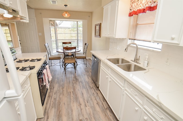 kitchen with dishwasher, hanging light fixtures, white gas range oven, sink, and white cabinetry