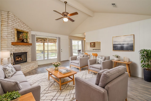 living room with vaulted ceiling with beams, a brick fireplace, ceiling fan, and hardwood / wood-style flooring