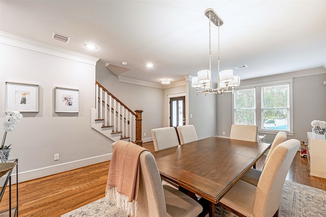 dining room featuring light hardwood / wood-style flooring, ornamental molding, and a chandelier