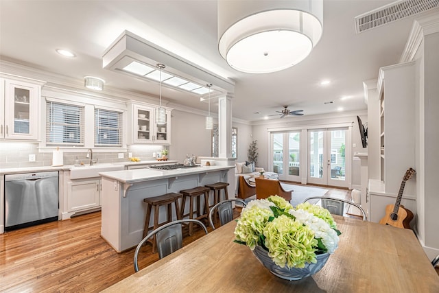 dining area featuring sink, crown molding, light hardwood / wood-style flooring, and ceiling fan