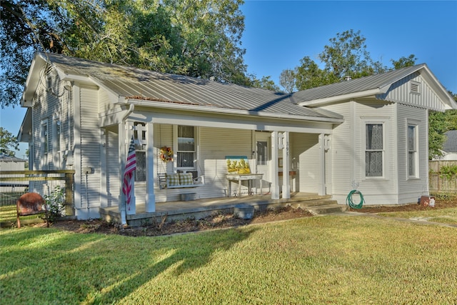 bungalow-style house featuring covered porch and a front yard