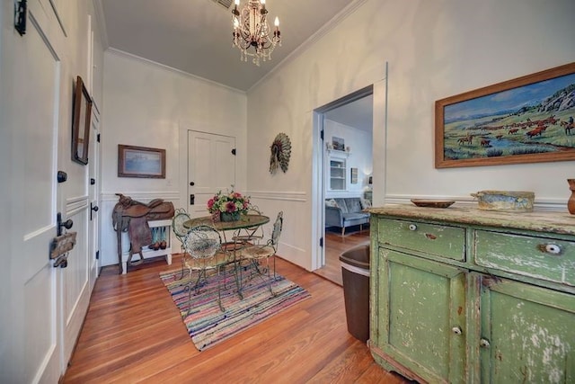 entrance foyer featuring a notable chandelier, light hardwood / wood-style floors, and crown molding