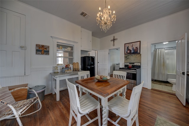 dining space with dark hardwood / wood-style flooring and a chandelier