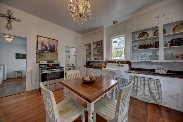 dining space featuring light hardwood / wood-style flooring, an inviting chandelier, and sink