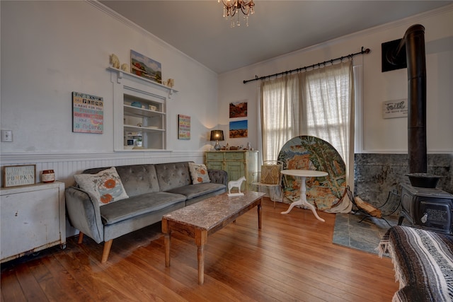 living room featuring crown molding, hardwood / wood-style floors, and a wood stove