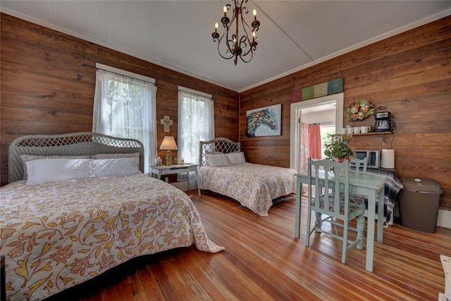 bedroom featuring ornamental molding, wood walls, and light hardwood / wood-style floors