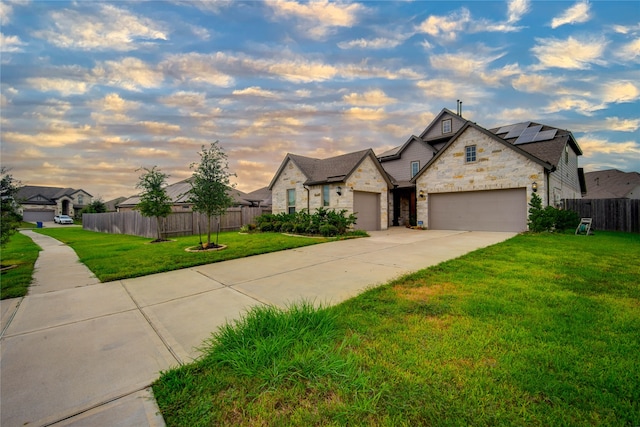 french provincial home featuring a lawn and a garage