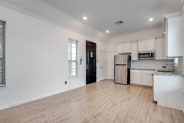 kitchen featuring light wood-type flooring, sink, white cabinets, appliances with stainless steel finishes, and crown molding