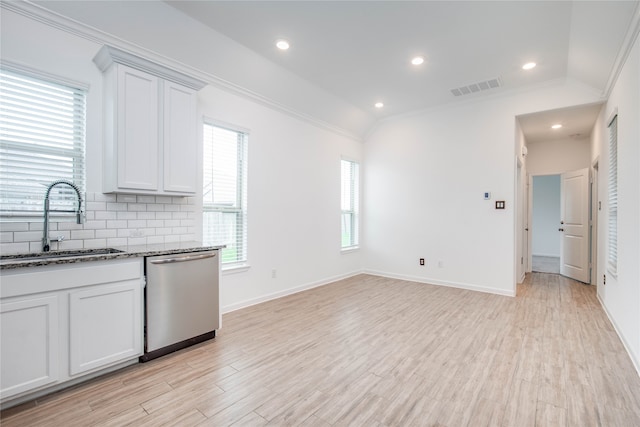 kitchen with crown molding, vaulted ceiling, dishwasher, and white cabinetry