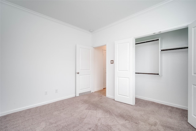 unfurnished bedroom with crown molding, light carpet, and a closet