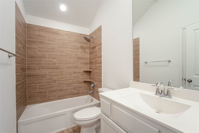 full bathroom featuring lofted ceiling, tiled shower / bath combo, vanity, and toilet