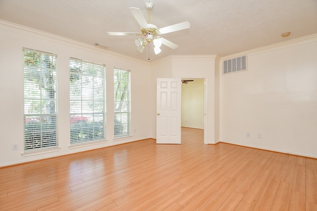 spare room featuring a textured ceiling, light hardwood / wood-style floors, ornamental molding, and ceiling fan