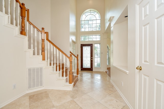 tiled entryway featuring a towering ceiling