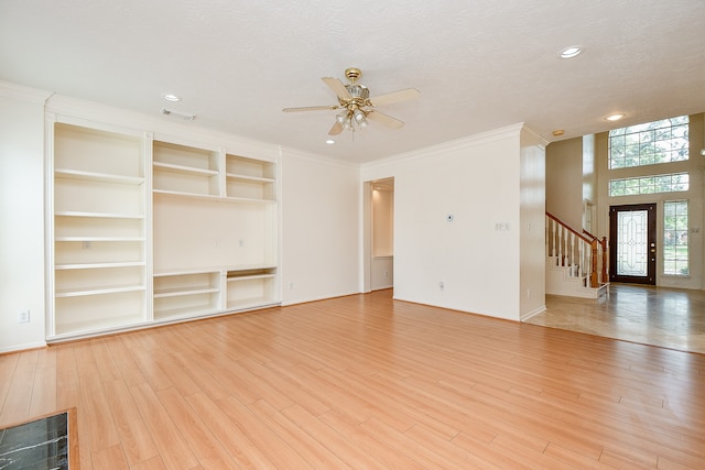 unfurnished living room featuring light hardwood / wood-style floors, crown molding, and a textured ceiling