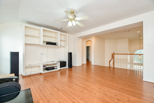 living room with ceiling fan, hardwood / wood-style floors, and a textured ceiling