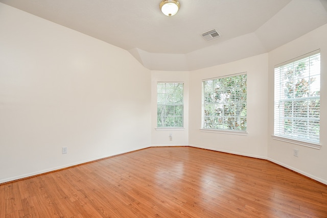 unfurnished room featuring light wood-type flooring and lofted ceiling