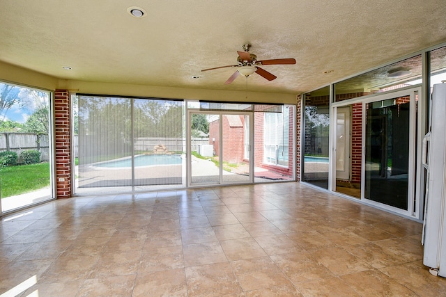 spare room with ceiling fan, light tile patterned flooring, and a textured ceiling