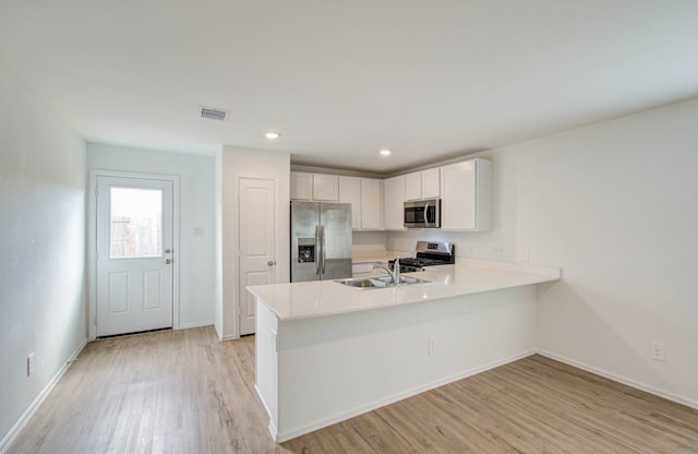 kitchen featuring light hardwood / wood-style flooring, stainless steel appliances, white cabinets, and kitchen peninsula